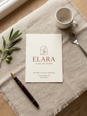 Flat-lay of a cream business card on a linen runner with an olive branch and fountain pen